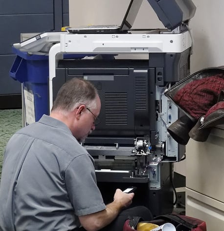 man repairing an office printer